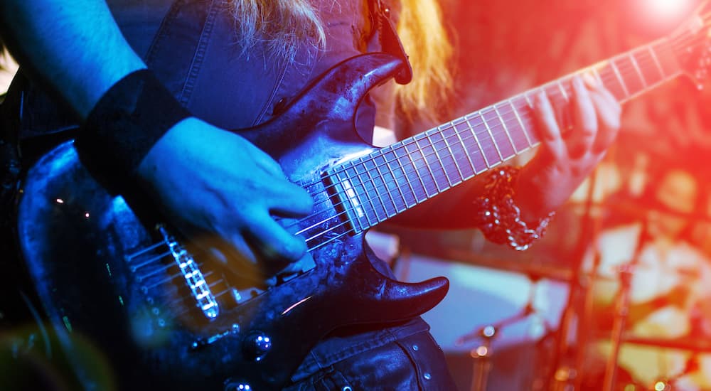Guitar neck close-up on a concert of rock music in the hands of a musician