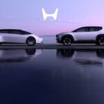 A white Honda 0 SALOON and a white Honda 0 SUV parked near water.