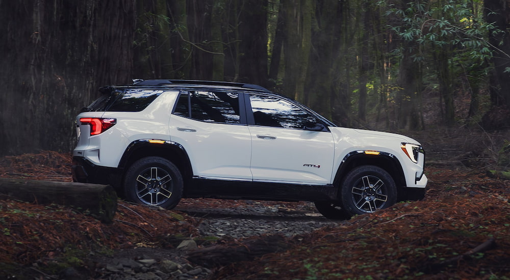 Side of a white 2026 GMC Terrain AT4 driving off-road.