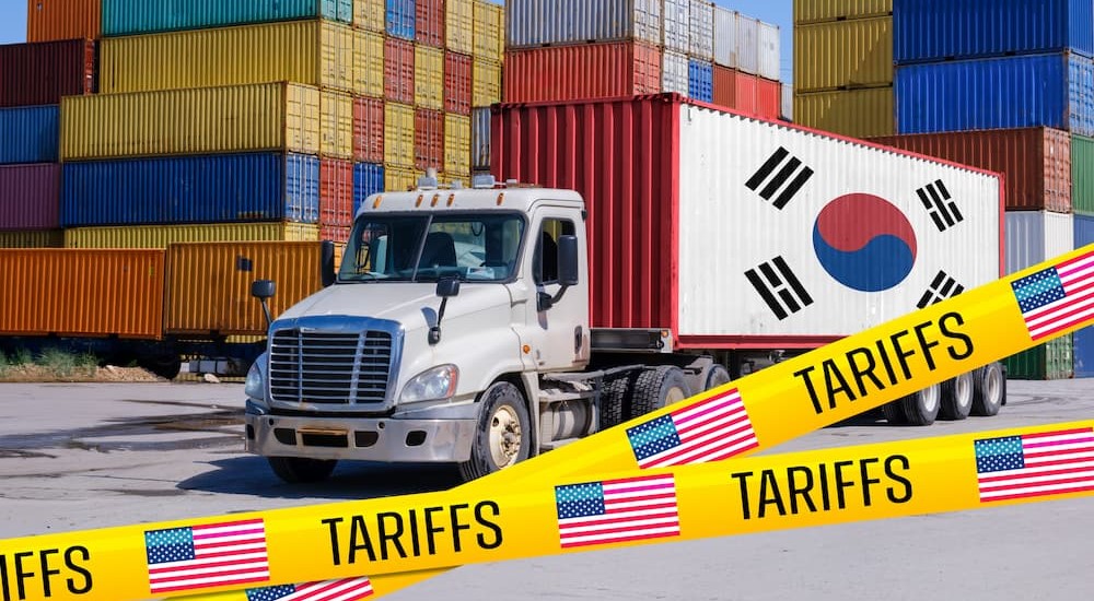 An 18-wheeler with a South Korean flag near many shipping containers.