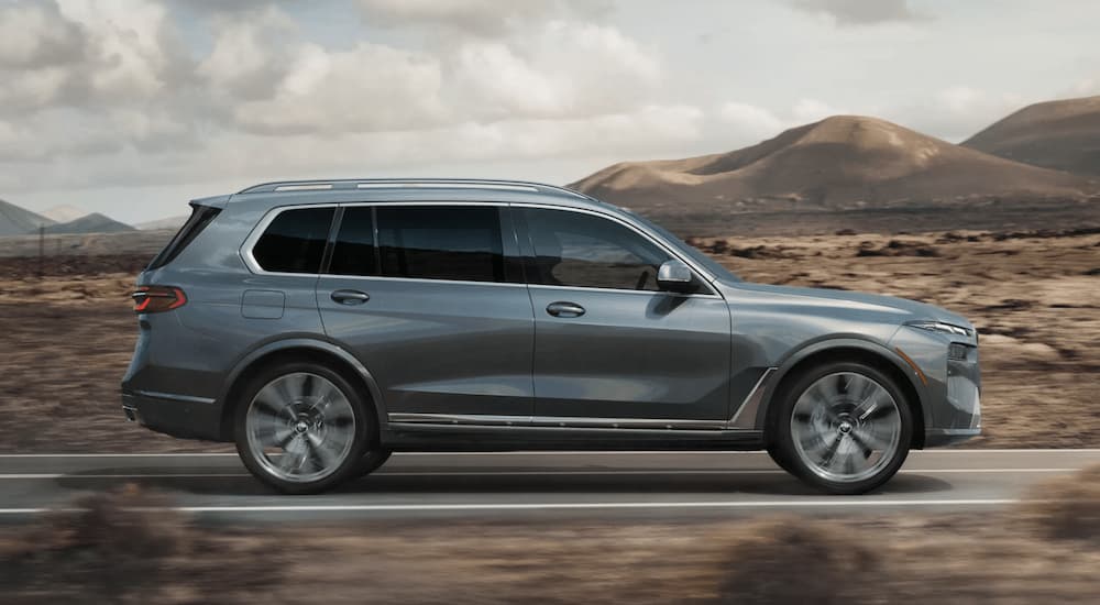 Grey 2025 BMW X7 driving on a desert highway
