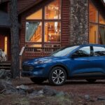 Blue 2022 Ford Escape parked outside of a cabin