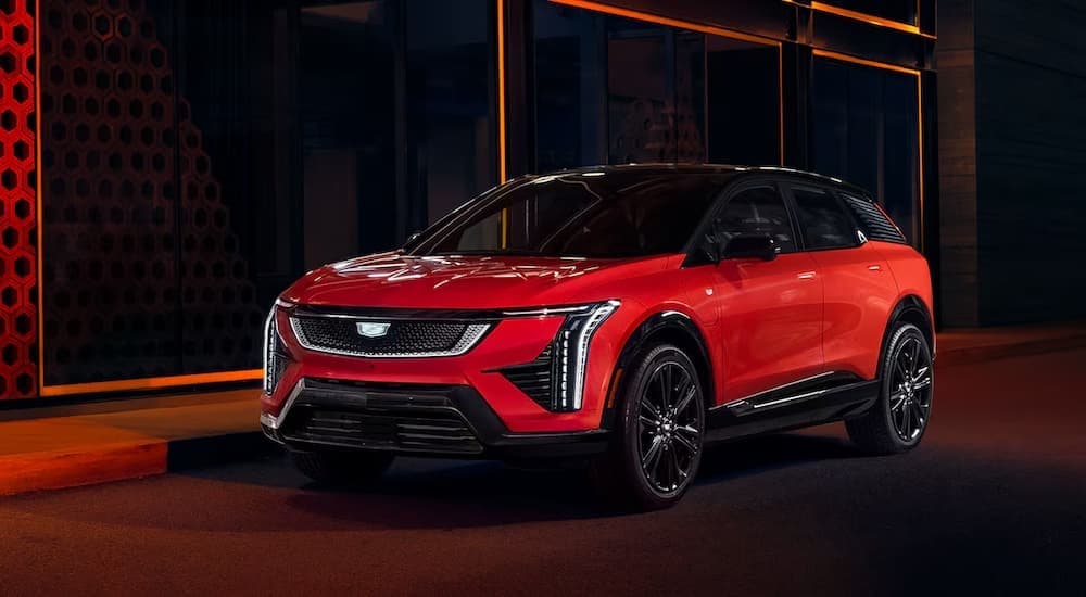 A red 2025 Cadillac OPTIQ parked in a city.