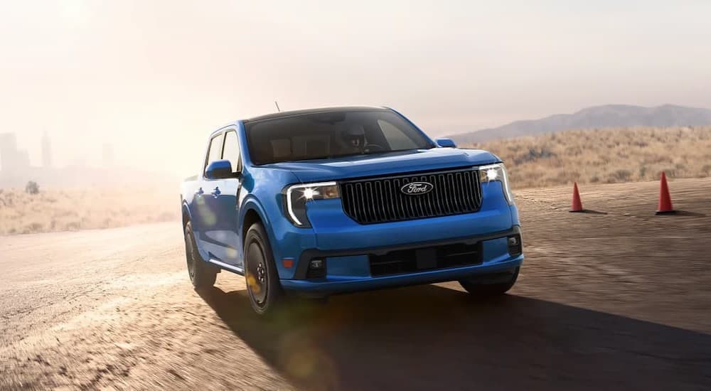 A blue 2025 Ford Maverick Lobo driving near cones.