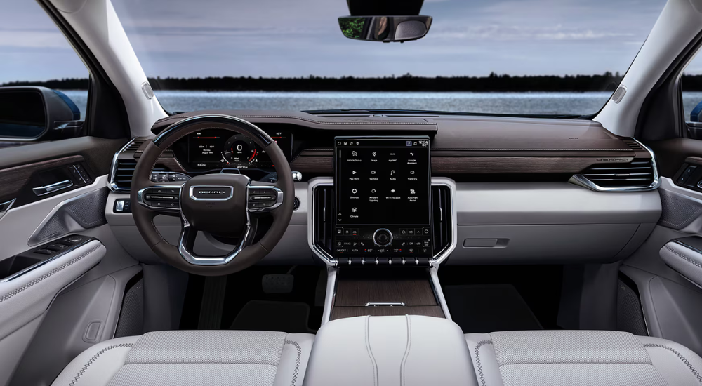 Premium white interior in a 2026 GMC Acadia parked outside a GMC dealer