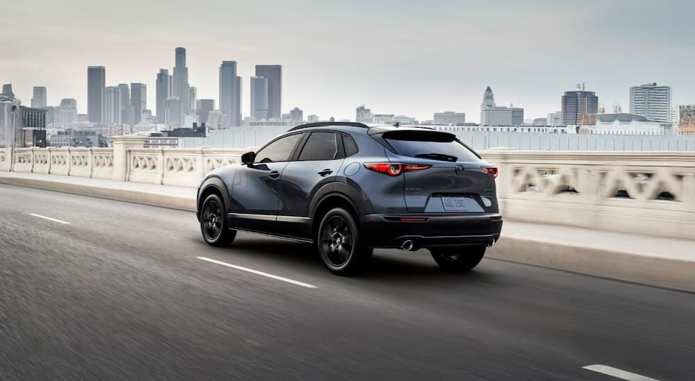 A blue 2026 Mazda CX-30 driving on a bridge.