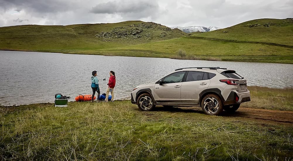 A tan 2026 Subaru Crosstrek Hybrid parked near water.
