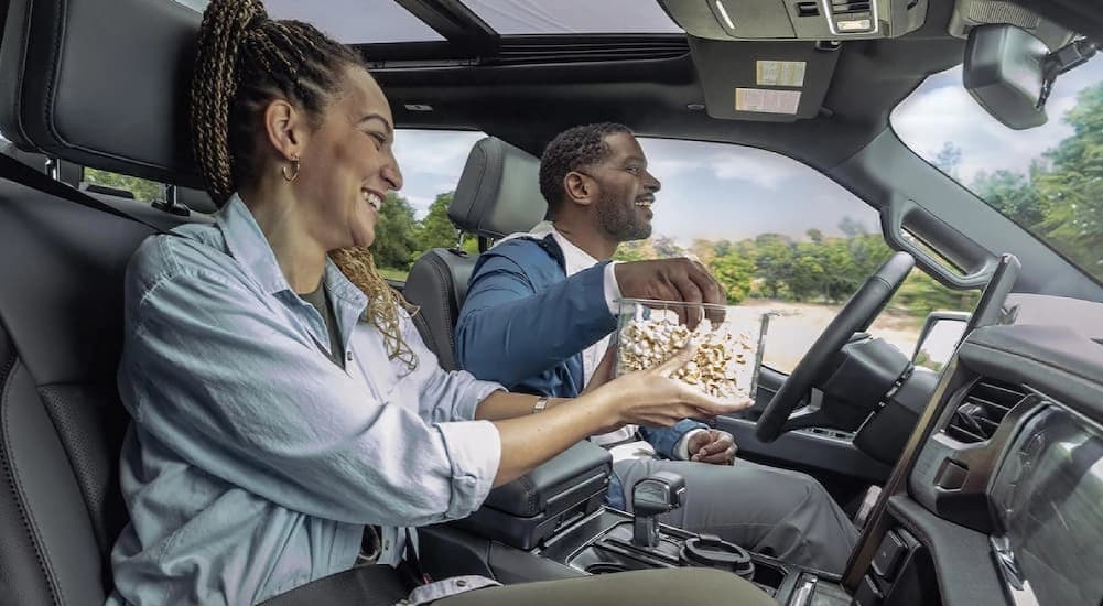 Two people driving in a 2025 Ford F-150 Lightning.