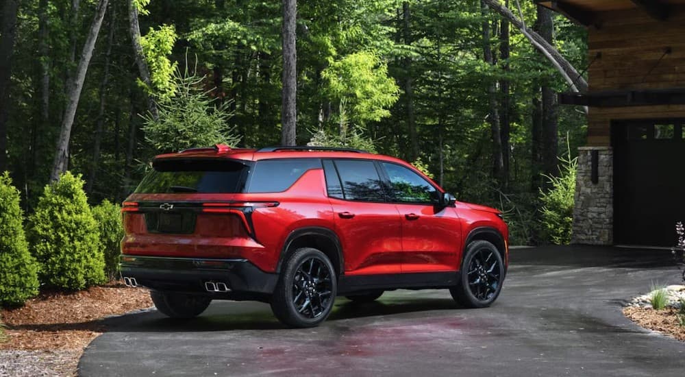 A red 2025 Chevy Traverse RS parked on a driveway.