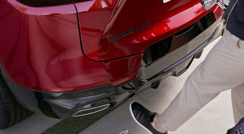 A man using the hands-free rear tailgate in a red 2026 Chevy Blazer