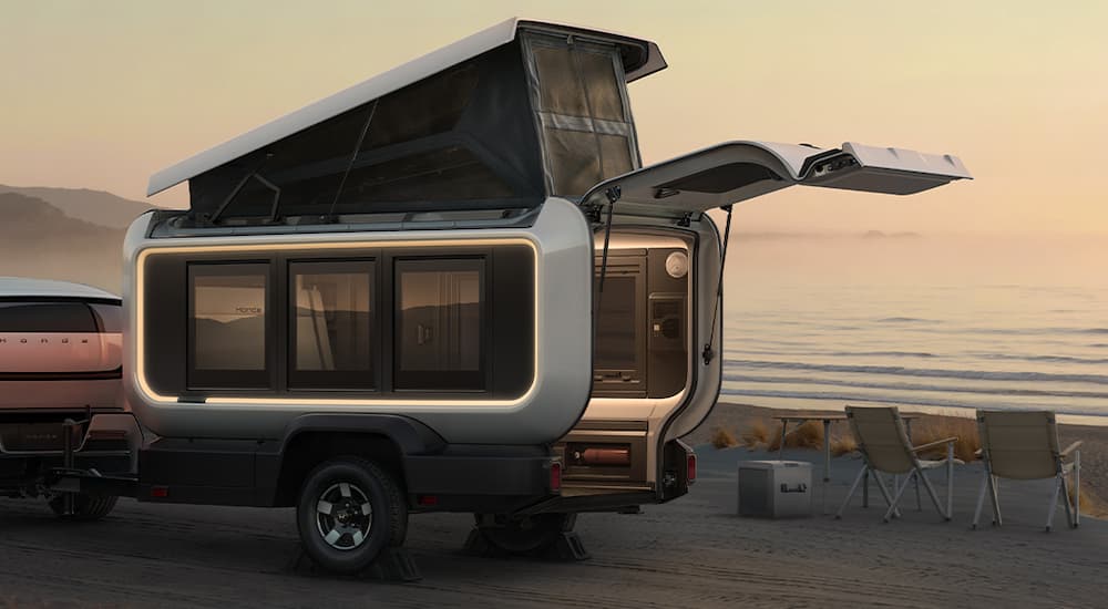 A Honda Base Station camper prototype with the door open at the beach