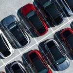 Aerial view of a parking lot of Tesla vehicles.