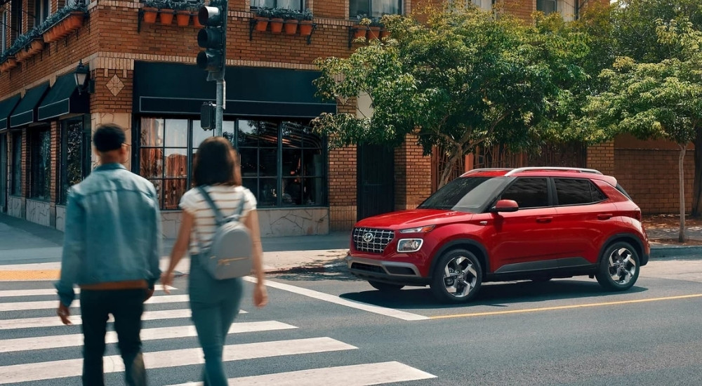 Red 2023 Hyundai Venue Limited stopped to let pedestrians cross the street