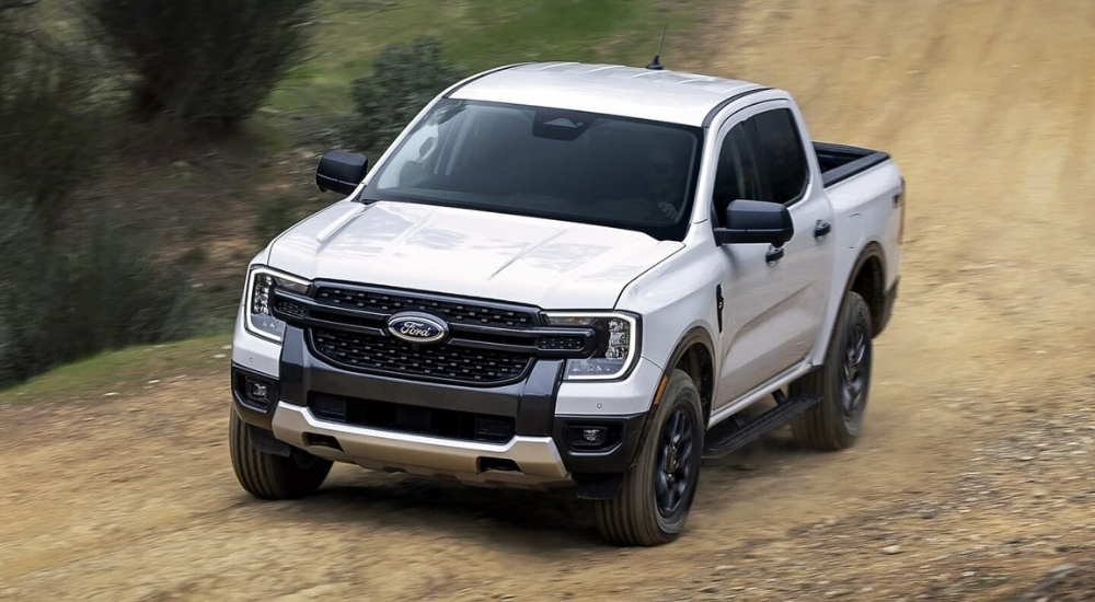 A white 2024 Ford Ranger shown driving a dirt path.