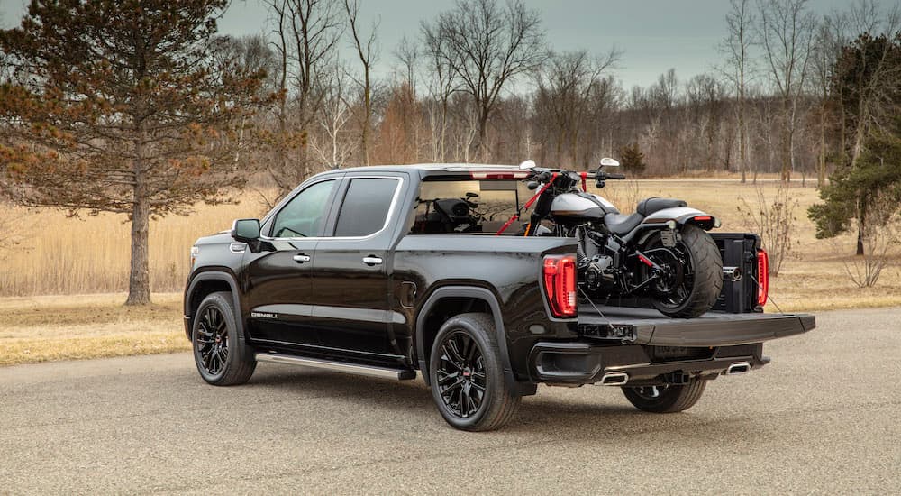 Black 2020 GMC Sierra 1500 Denali with a motorcycle in the bed