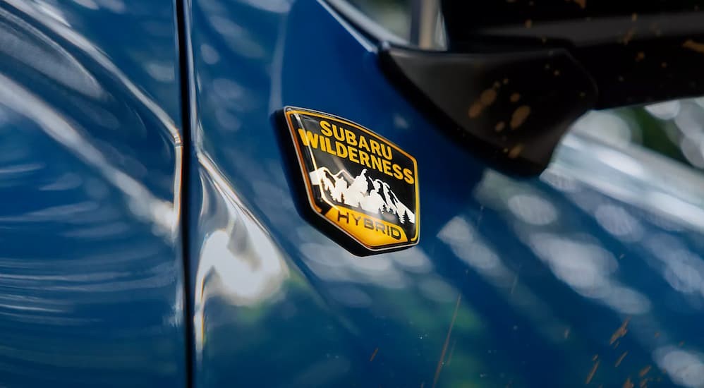 Close-up of a badge on a blue 2027 Subaru Forester Hybrid.