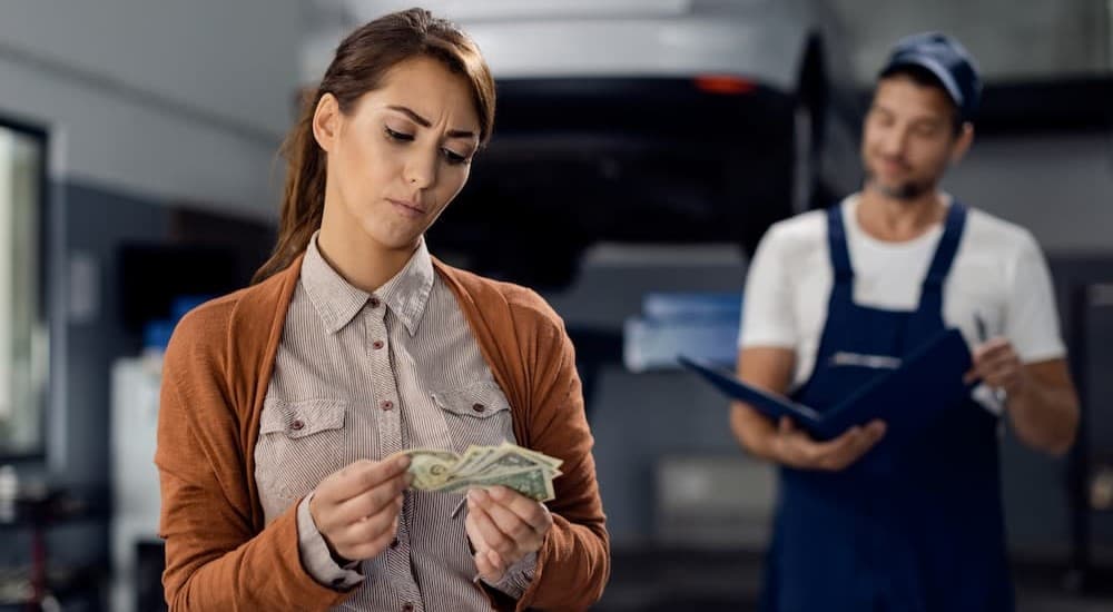 A person counting money near a technician.