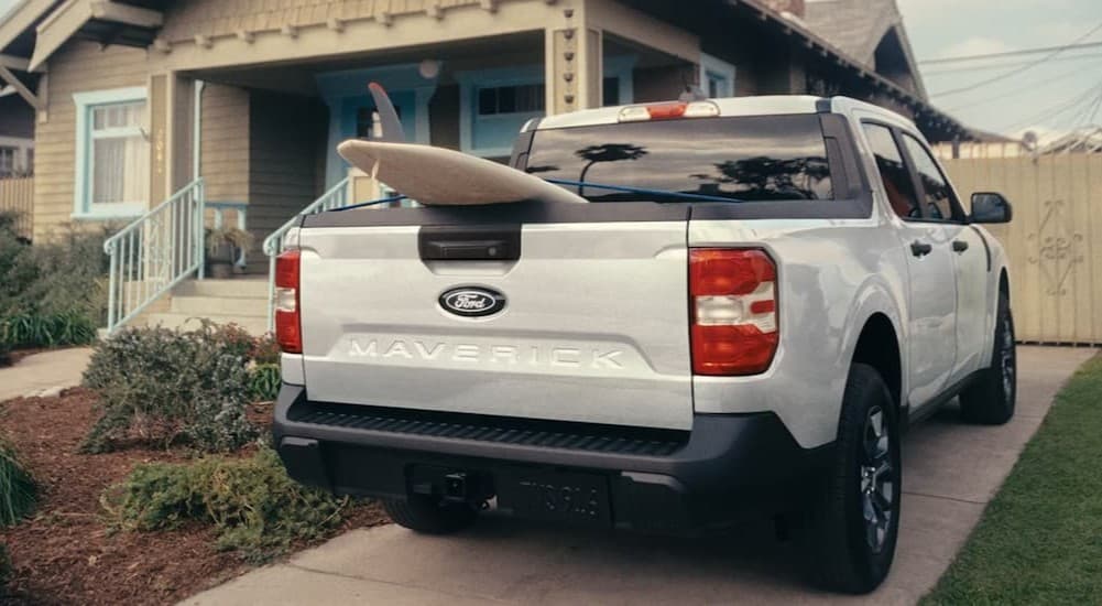 A white 2026 Ford Maverick parked near a house.