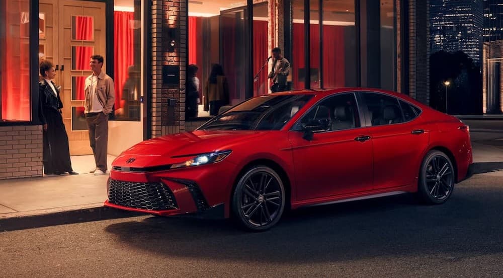 A red 2026 Toyota Camry parked in a city.